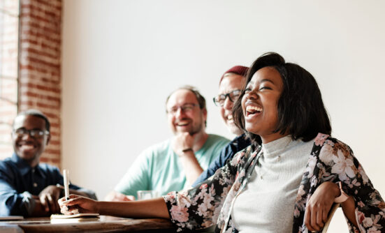 Woman smiling at table with other people
