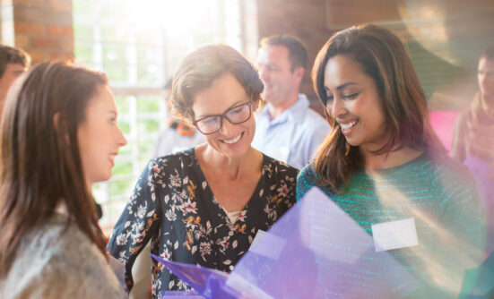 Three women discussing a report
