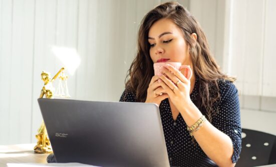 Woman on a laptop holding a mug