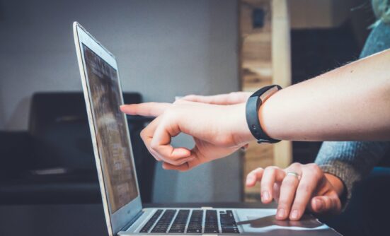 Hands of people pointing at a laptop screen