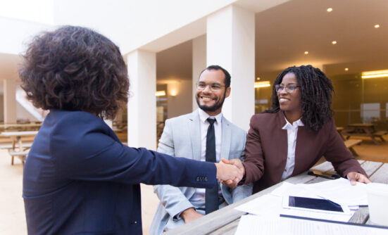 Two women and a man at work talking