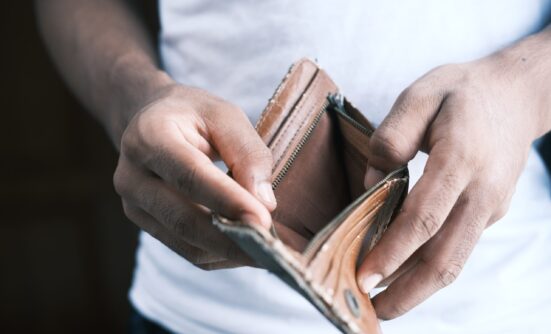 A pair of hands opening a wallet which shows nothing inside